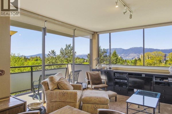 Living room with large windows, seating area, and balcony overlooking Vancouver skyline. - 900 1685 W 14th Avenue, Vancouver