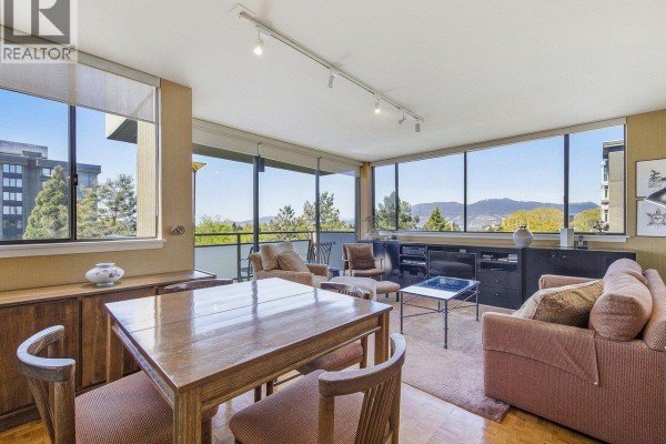 Living and dining area with large windows, furniture, and view of Vancouver. - 900 1685 W 14th Avenue, Vancouver