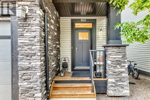 Close-up of the front entrance to townhouse 901, with stone pillars and a grey door. - 901, 110 Coopers Common Sw, Airdrie