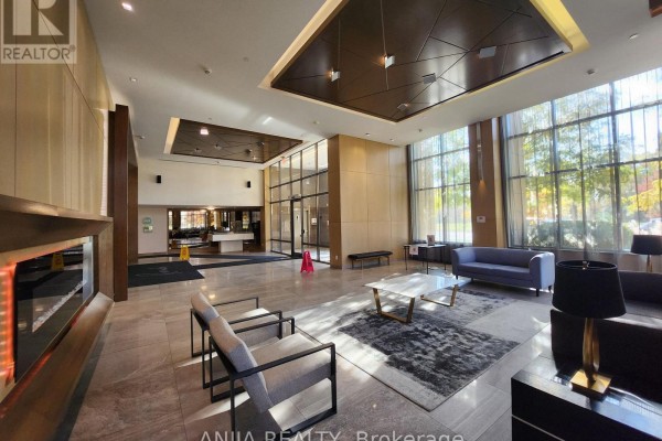 Building lobby with marble floors, modern furniture, fireplace, and large windows. - 901 - 18 Uptown Drive, Markham