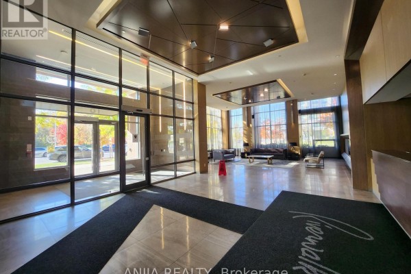 Spacious building lobby with glass entrance, seating areas, and large windows. - 901 - 18 Uptown Drive, Markham