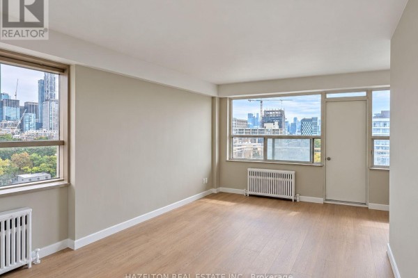 Living room with multiple windows offering city views and light wood flooring. - 901 - 206 St George Street, Toronto