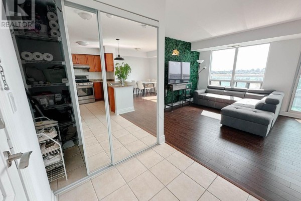 Apartment entryway with mirrored closet doors, leading to living area and kitchen. - 901 - 935 Sheppard Avenue W, Toronto