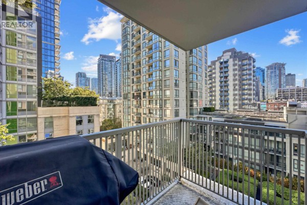 View from balcony with metal railing, city buildings, and green rooftop foliage. - 901 1055 Richards Street, Vancouver