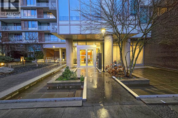 Walkway leading to building entrance with glass doors, trees, and modern architecture. - 901 8131 Nunavut Lane, Vancouver