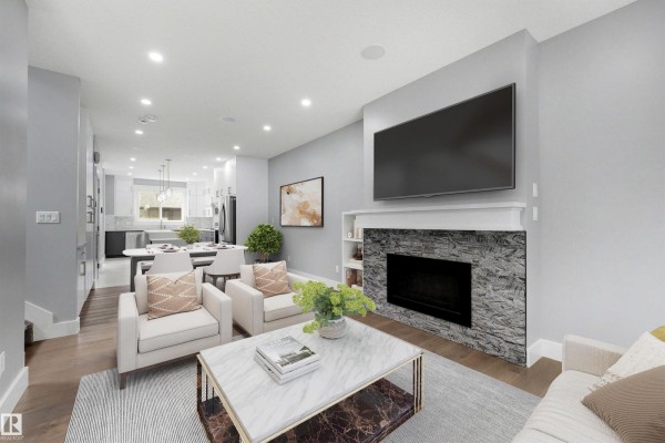 Living room with light grey walls, fireplace, and open-concept view to dining and kitchen. - 9013 90 St Nw, Edmonton