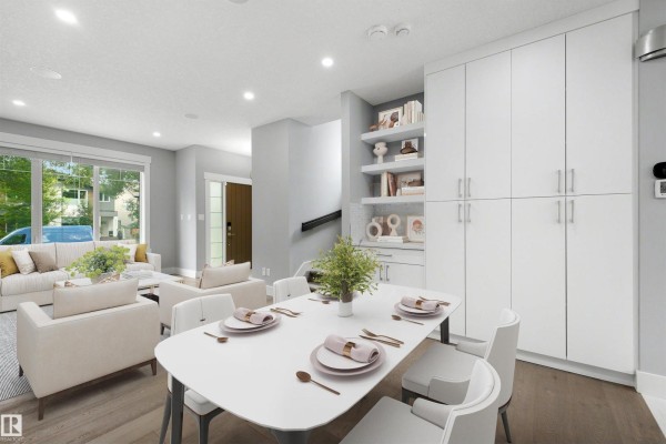 Dining area with a white table, chairs, and a large wall of white cabinets. - 9013 90 St Nw, Edmonton
