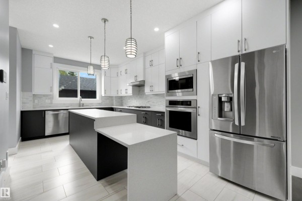 Contemporary kitchen with two-tone cabinets, quartz countertops, stainless steel appliances, and island. - 9013 90 St Nw, Edmonton