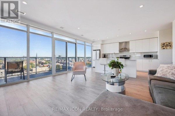 Spacious living room with kitchen access, stainless steel fridge, and contemporary furnishings. - 902 - 15 Glebe Street, Cambridge