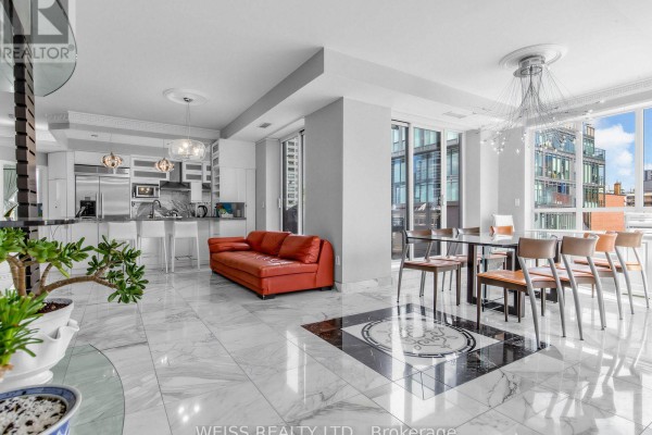 Open concept living area with red sofa, dining table, and kitchen. - 902 - 18 Beverley Street, Toronto