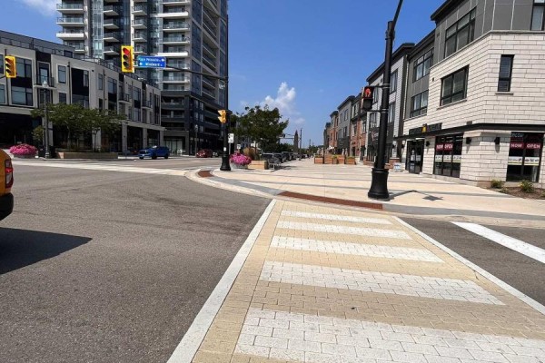 Intersection view with traffic lights, crosswalk, and storefronts along the street. - 902 - 385 Winston Road, Grimsby