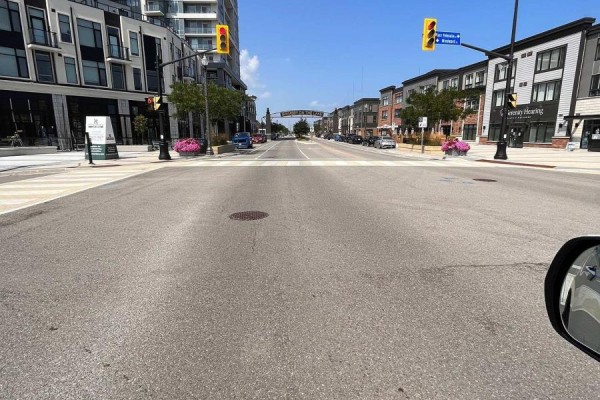 Street view from a car looking down a road lined with buildings and shops. - 902 - 385 Winston Road, Grimsby