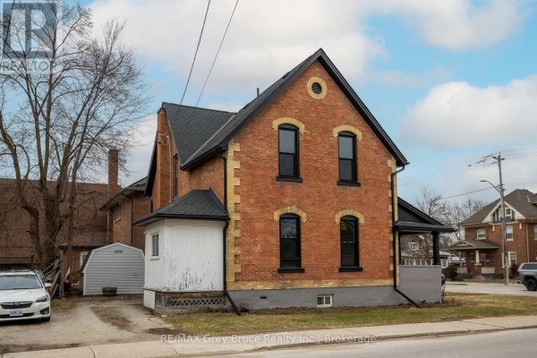 Side view of the brick house, showing a bay window and a small covered entryway. - 902 2nd Avenue W, Owen Sound