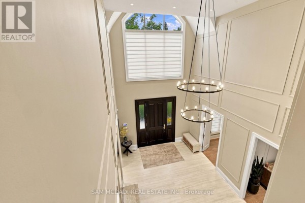 View from above of a large, open foyer with a vaulted ceiling, modern circular light fixtures, and double doors. - 902 Parkland Avenue, Mississauga