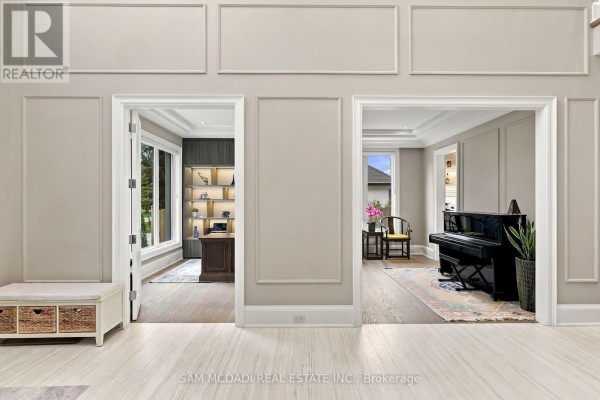 View of an office with built-in shelving and a piano room with a black grand piano. - 902 Parkland Avenue, Mississauga