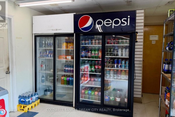 Refrigerated display cases filled with drinks and snacks are inside the convenience store. - 90279 London Road N, North Huron