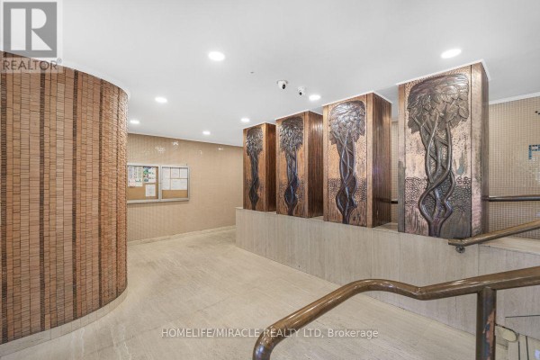 Building lobby with ornate copper relief art on walls and marble flooring. - 903 - 40 Panorama Court, Toronto