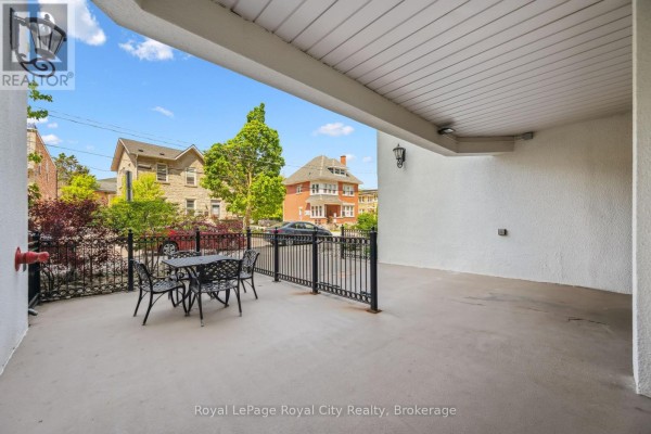 Outdoor patio area with a black metal table and chairs. - 903 - 55 Yarmouth Street, Guelph