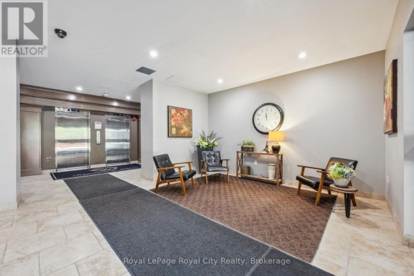 Building lobby with elevators, seating area, and tiled floor. - 903 - 55 Yarmouth Street, Guelph