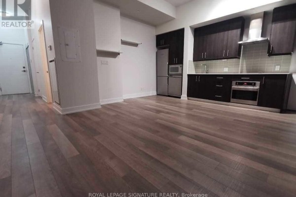 View of the living area and kitchen, showing the entrance door and hallway on the left, and the open space. - #903 - 75 The Donway W, Toronto