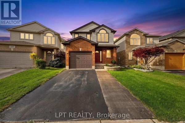 Exterior of a two-story brick and siding house with a double-car driveway and lawn at dusk. - 903 Bradshaw Crescent, London North