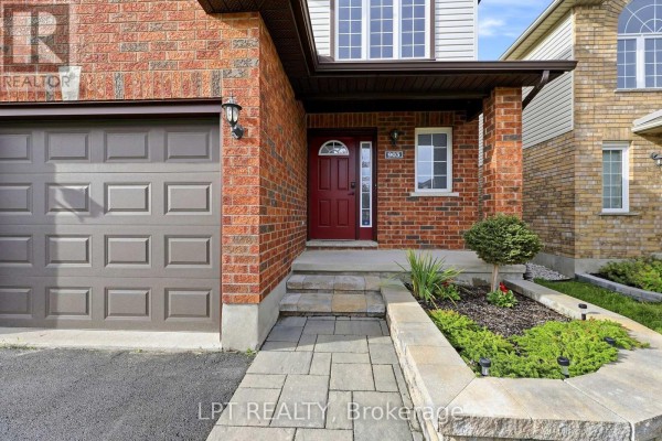 Close-up of the front entrance of a house with a red door, brick facade, and garage door. - 903 Bradshaw Crescent, London North