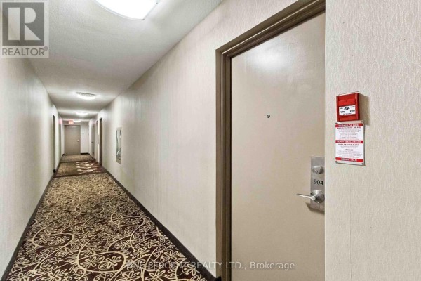 Interior hallway of an apartment building with a patterned carpet and unit doors. - 904 - 15 Elizabeth Street N, Mississauga