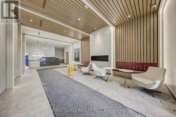 Modern lobby with wood paneling, seating area, and a reception desk. - 904 - 2369 Danforth Avenue, Toronto