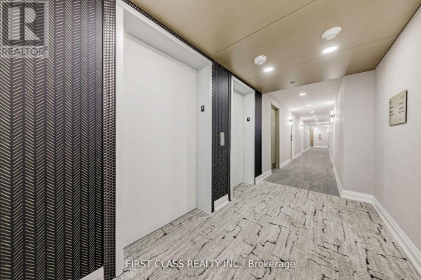Elevator area in a hallway with patterned wallpaper and carpeted flooring. - 904 - 2369 Danforth Avenue, Toronto