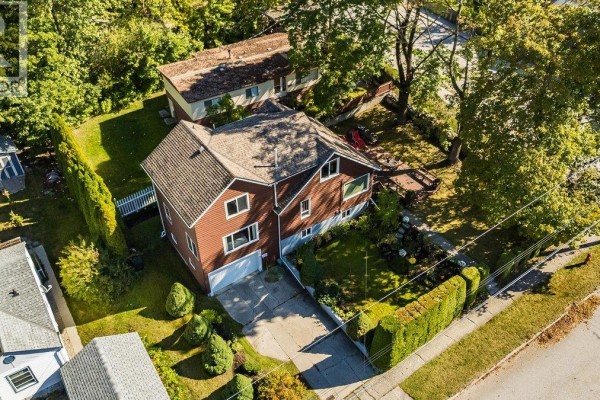 Aerial view of a house with brown siding, a pitched roof, and a green lawn. - 904 Fifth Street, Nelson