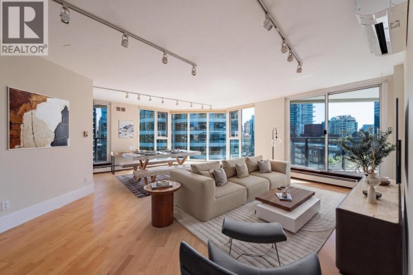 Living room with large sectional sofa, coffee table, and sliding glass doors to balcony with city views. - 905 1010 Burnaby Street, Vancouver