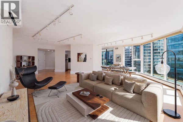Living room features a beige sofa, black accent chair, and floor-to-ceiling windows with city views. - 905 1010 Burnaby Street, Vancouver