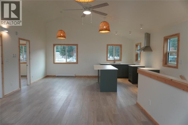 Open concept living area with light wood floors and vaulted ceiling. - 905 13 Avenue S, Golden