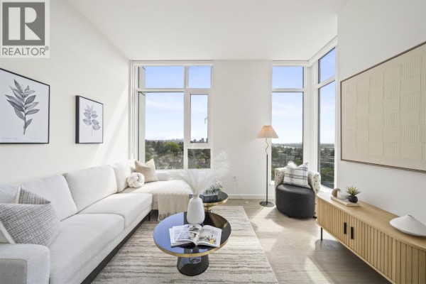 Living room with white sectional sofa, patterned accent chair, and large floor-to-ceiling windows. - 905 8415 Granville Street, Vancouver