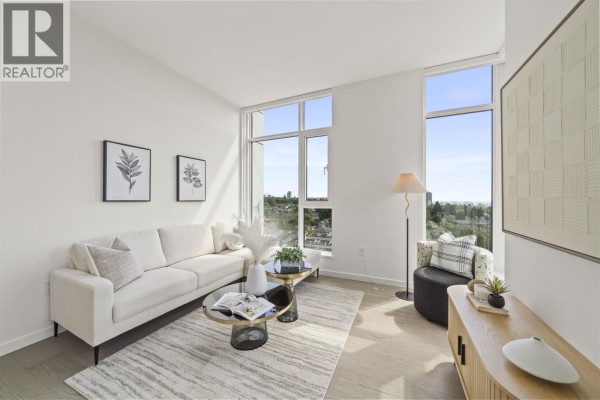 Corner of a living room with a white sofa, accent chair, coffee table, and large windows. - 905 8415 Granville Street, Vancouver