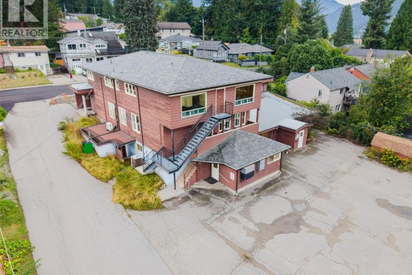 Side aerial view of the commercial building with exterior stairs and the parking area. - 905-909 Gordon Street, Nelson