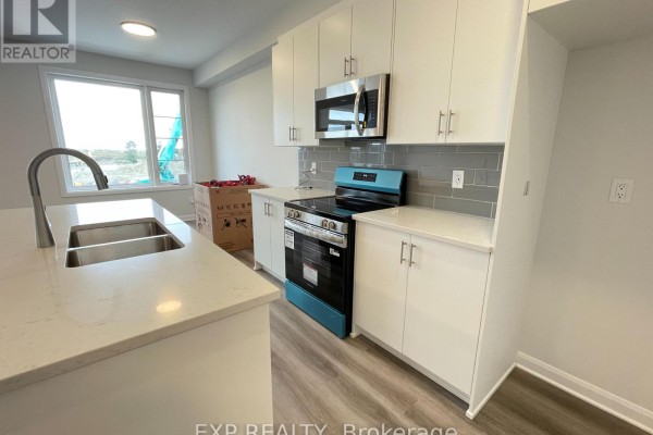Kitchen with white cabinets, quartz countertops, stainless steel appliances, and a blue gas range. - 905 Jack Dalgity Street, Mississippi Mills