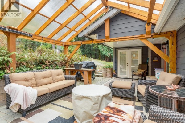 Covered patio with wicker furniture, a grill, and French doors leading inside. - 905 Worrall Dr, Langford