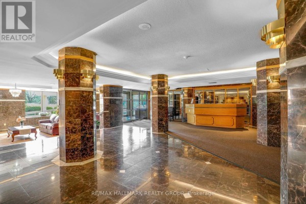 Building lobby with marble floors, dark marble columns, and a reception desk. - 906 - 960 Teron Road, Ottawa