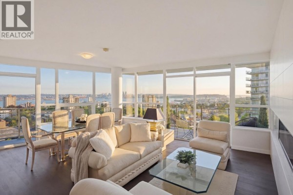 Open concept kitchen and living area with wood cabinetry and large island. - 906 112 E 13th Street, North Vancouver
