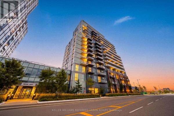 Modern condo building exterior with balconies and glass walkway, illuminated at dusk. - 907 - 10 Honeycrisp Crescent, Vaughan