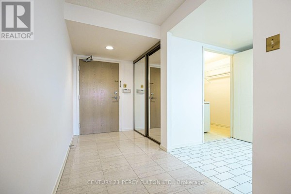 Stacked white washer and dryer unit in a small laundry closet. - 907 - 5 Kenneth Avenue, Toronto