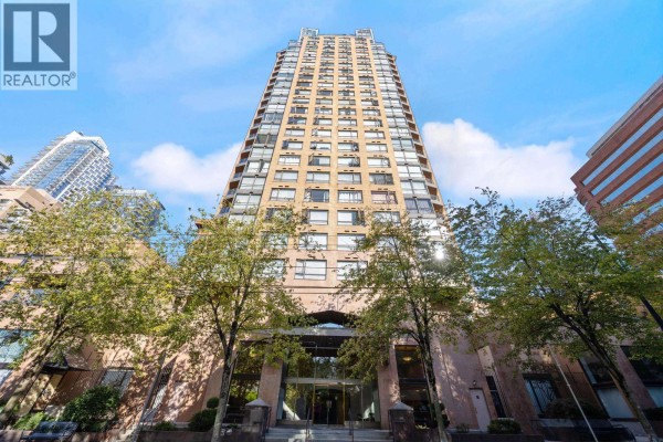 Low-angle shot of a tall apartment building with a glass entrance and trees in front. - 907 1189 Howe Street, Vancouver