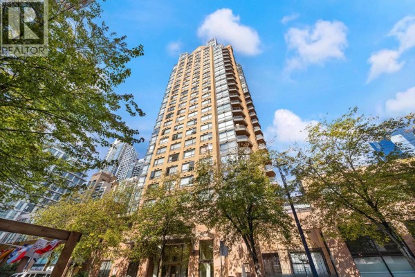 Wide-angle view up at a tall apartment building facade with trees in the foreground. - 907 1189 Howe Street, Vancouver