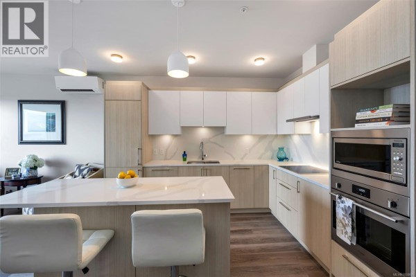 Kitchen and living area with balcony access, modern furnishings, and city views. - 907 622 Admirals Rd, Esquimalt
