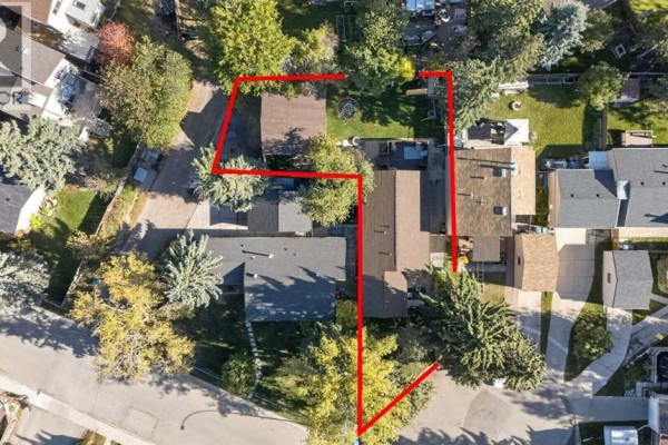 Aerial view of a property with a house, garage, and fenced backyard at 907 Ranchview Crescent Nw. - 907 Ranchview Crescent Nw, Calgary