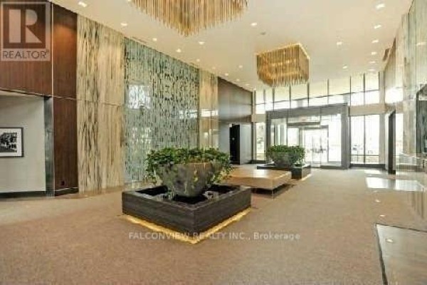 Spacious building lobby with textured walls, water features, and decorative lighting. - 908 - 215 Sherway Gardens Road, Toronto