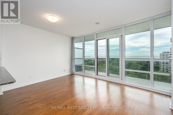 Living area with hardwood floors and large windows offering an expansive view. - 908 - 2240 Lake Shore Boulevard W, Toronto