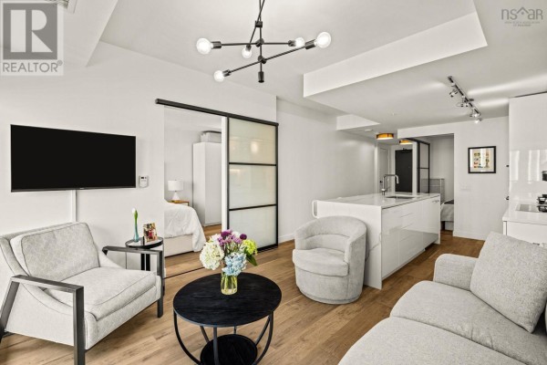 Open-concept living space with kitchen, dining area, and modern furnishings. - 908 1650 Granville St, Halifax