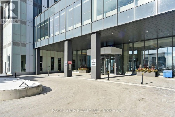 Driveway leading to the apartment building entrance with glass doors. - 909 - 10 Honeycrisp Crescent, Vaughan